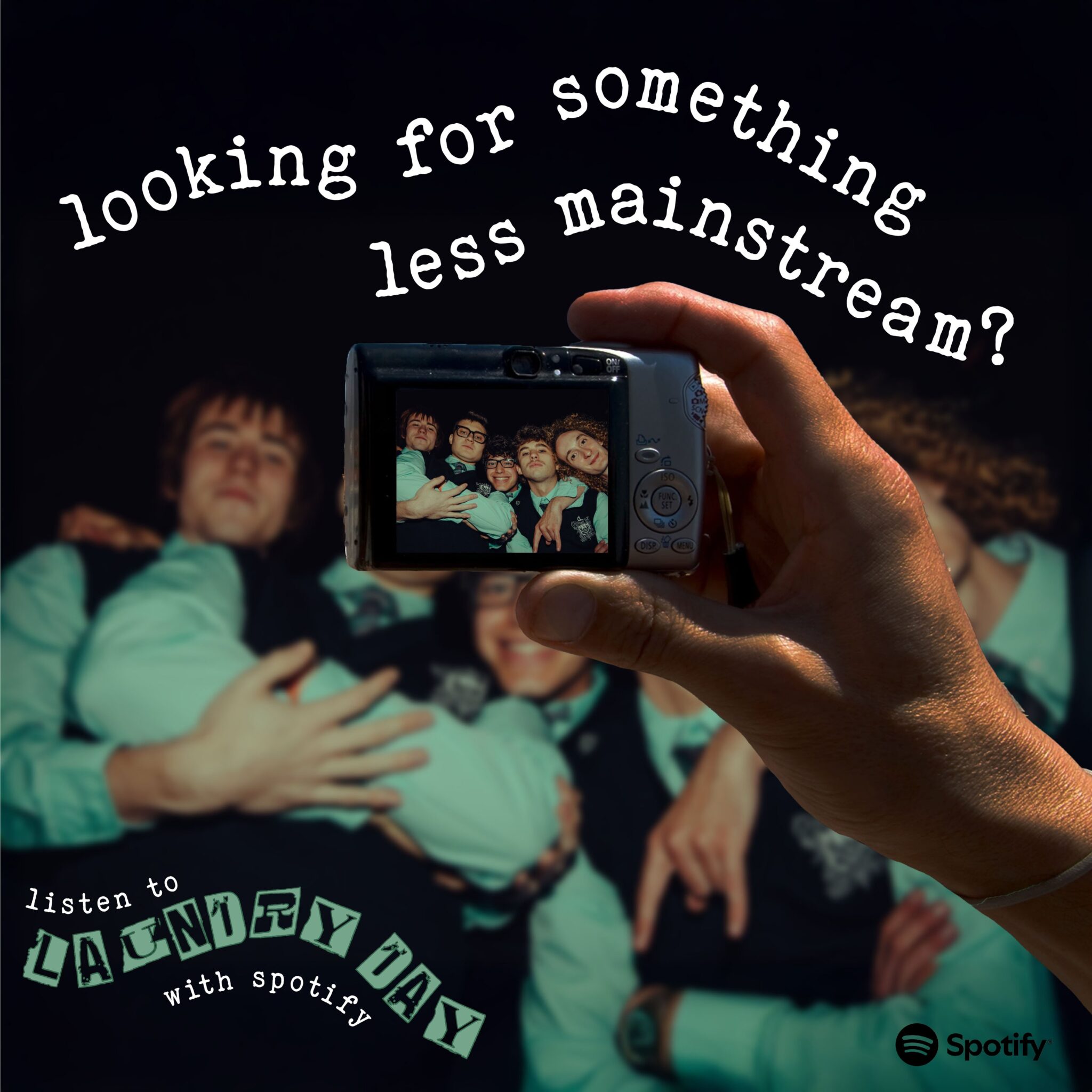 Social post: a hand holds up a camera to a band in a dark room; typewriter text reads “looking for something less mainstream?” and “listen to Laundry Day with Spotify”